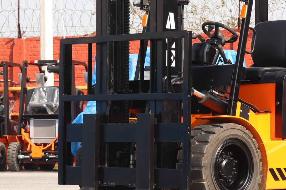 The mast and forks of a forklift standing in a yard