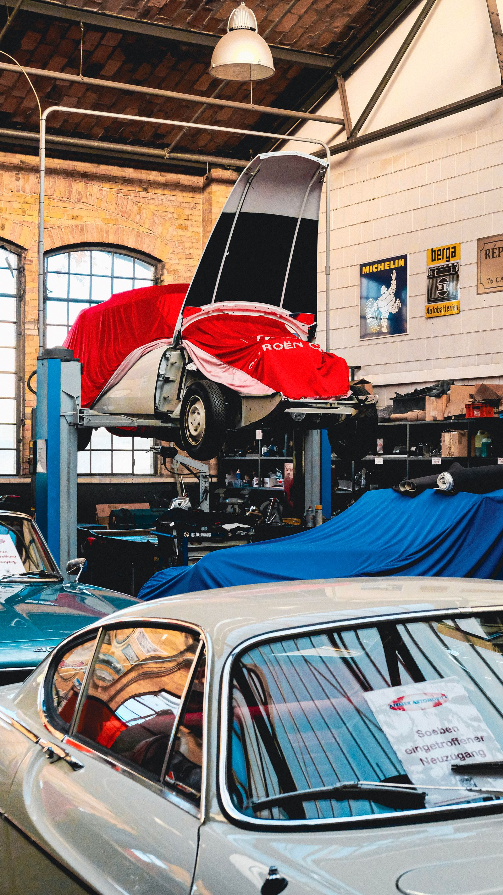 Cars raised on a two-post lift in a workshop.